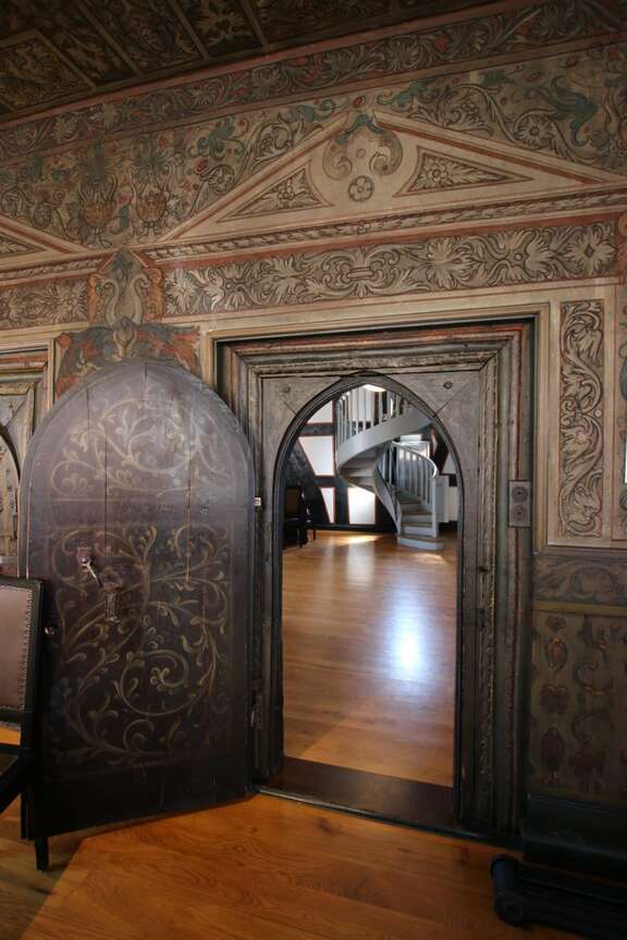 Vergrößerte Ansicht: Zimmer mit verzierter Holztür und bemalten Wänden