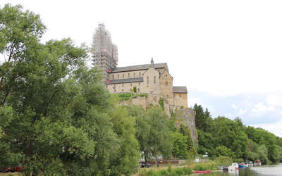 unverputzte Kirche auf Felsen, Turm ist eingerüstet