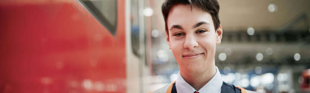 Lokführer in Warnweste neben einer S-Bahn