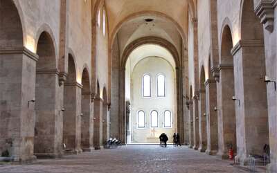Kircheninnenraum mit gepflastertem Steinboden, Pfeilern und Bögen