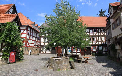 Vergrößerte Ansicht: Alter Brunnen auf Vorplatz vor Fachwerkhäusern