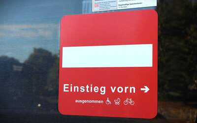 rotes Schild mit weißem Strich, Schrift: Einstieg vorn"