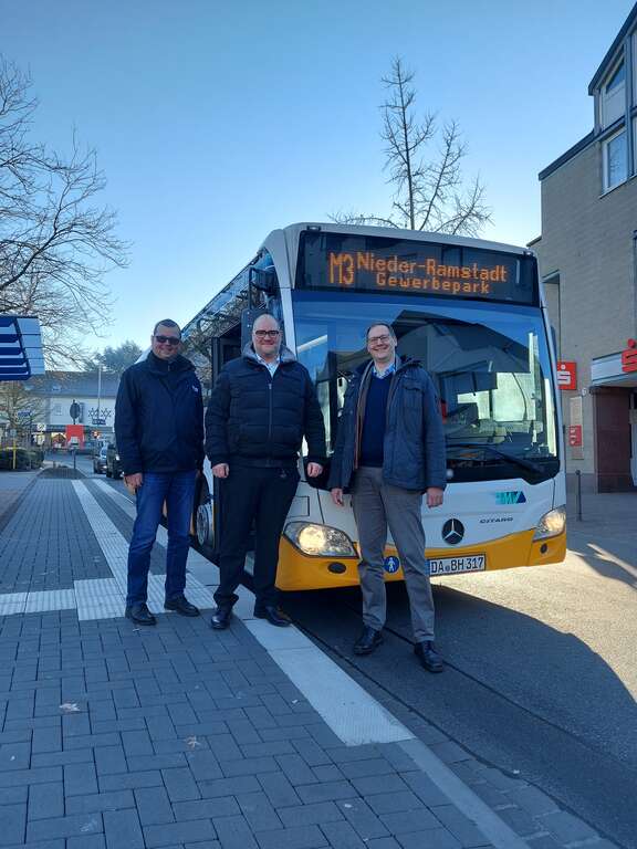 Aus N wird M: Vor-Ort-Termin in Mühltal Drei Männer stehen vor einem Bus.