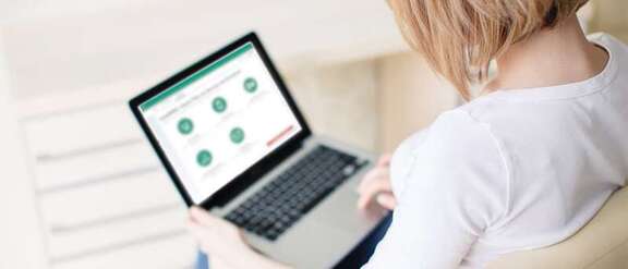 Woman with laptop on her knees showing the RMV website