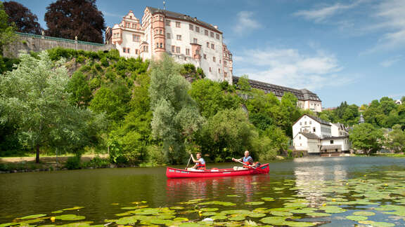 Vergrößerte Ansicht: rotes Kanu auf der Lahn, blauer Himmel, sattes Grün