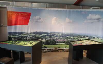 Zwei Tische vor einer Stehwand mit Landschafstaufnahme vom Vogelsberg