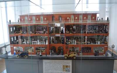 Großes Puppenhaus in Glasvitrine