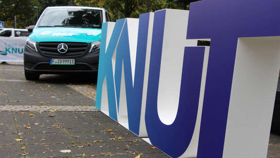 Vorderansicht des Elektroshuttles, aufgestellte Kunststoffbuchstaben "KNUT"
