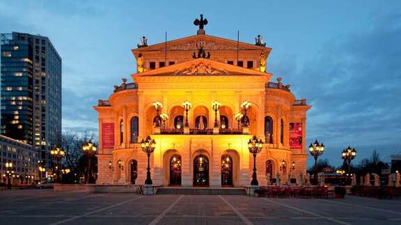 Klassizistisches Gebäude auf einem Platz, am Abend beleuchtet