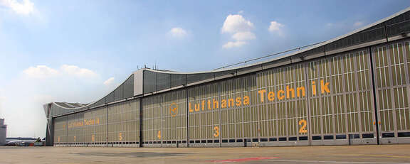 Vergrößerte Ansicht: riesige Wartungshalle mit Aufschrift: Lufthansa Technik