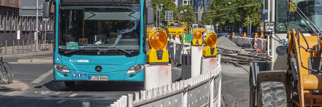 Baustelle mit Gleisbauarbeiten und Linienbus mit der Zielanzeige SEV.