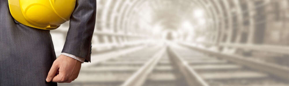 Nahaufnahme Mann mit gelben Helm, auf Gleisen im Tunnel